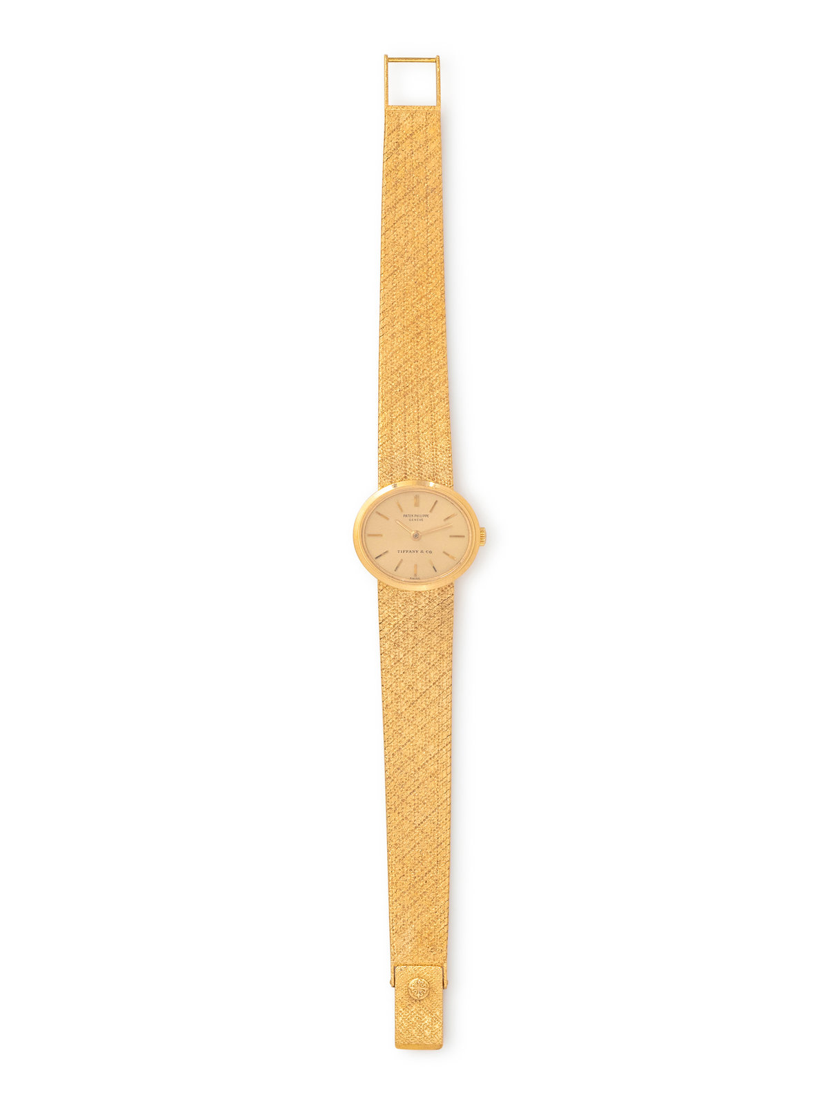 Double-signed Patek Philippe for Tiffany & Co. 18K yellow-gold watch with champagne dial and integrated textured bracelet, manual wind, Swiss hallmarks.