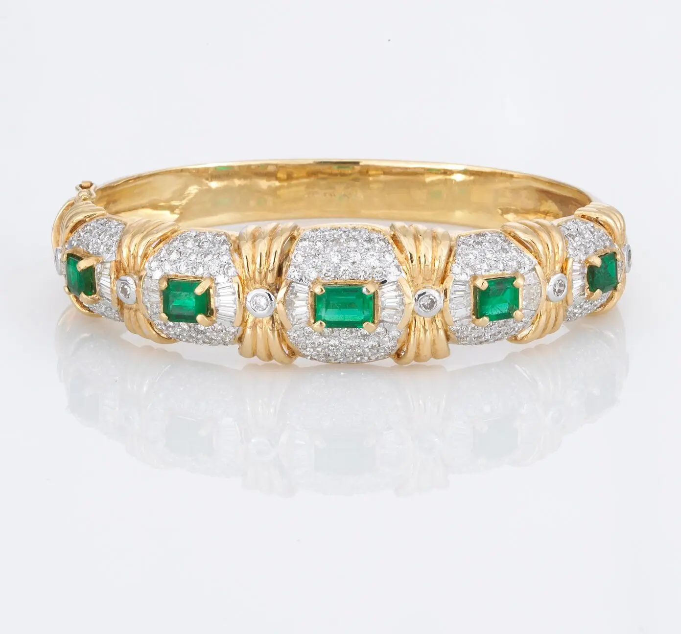 18k gold hinged bangle bracelet set with rectangular green emeralds and baguette diamonds