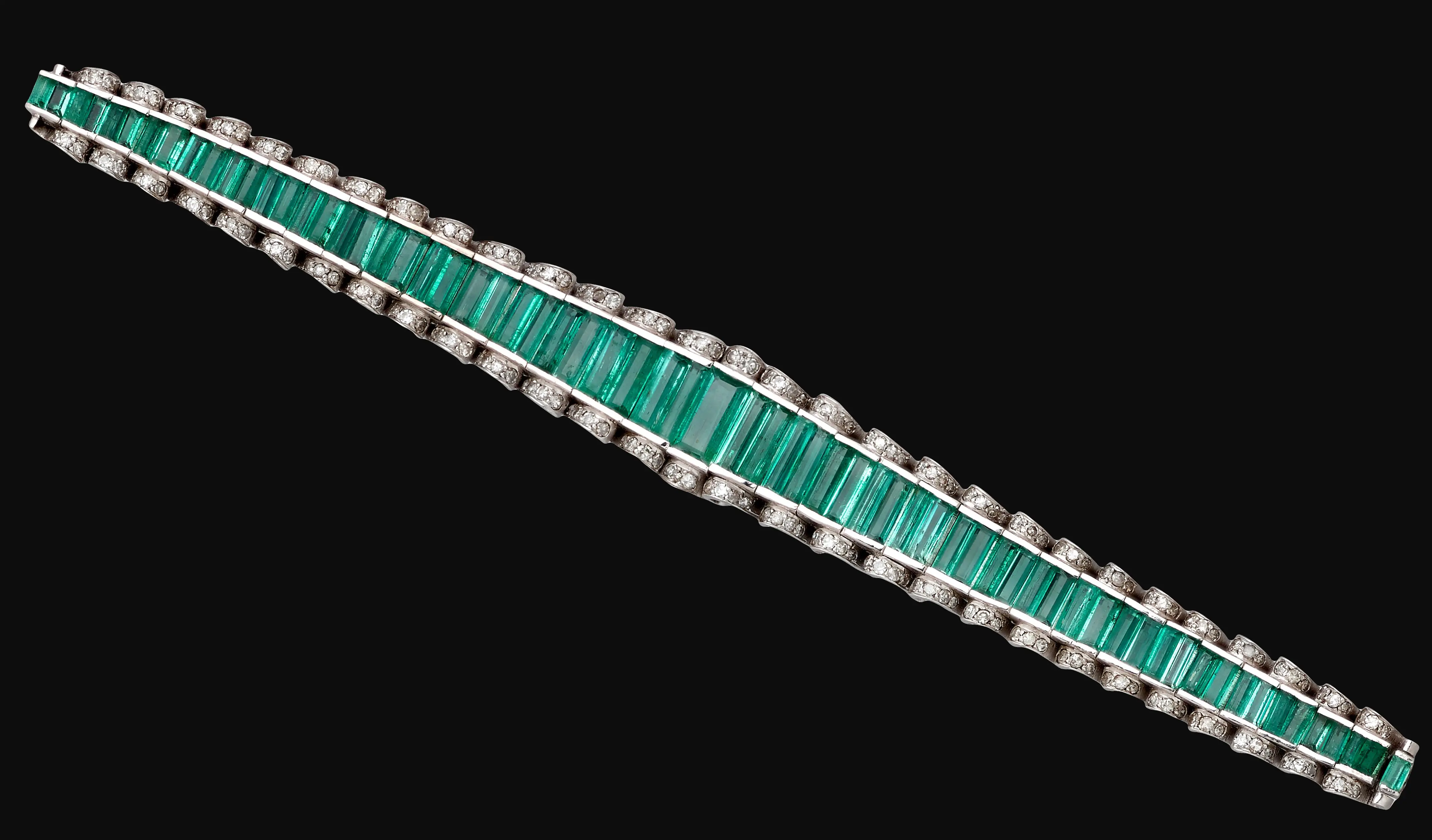 Palladium bracelet set with a continuous line of octagonal step-cut Colombian emeralds bordered by colorless diamonds, 7-inch length