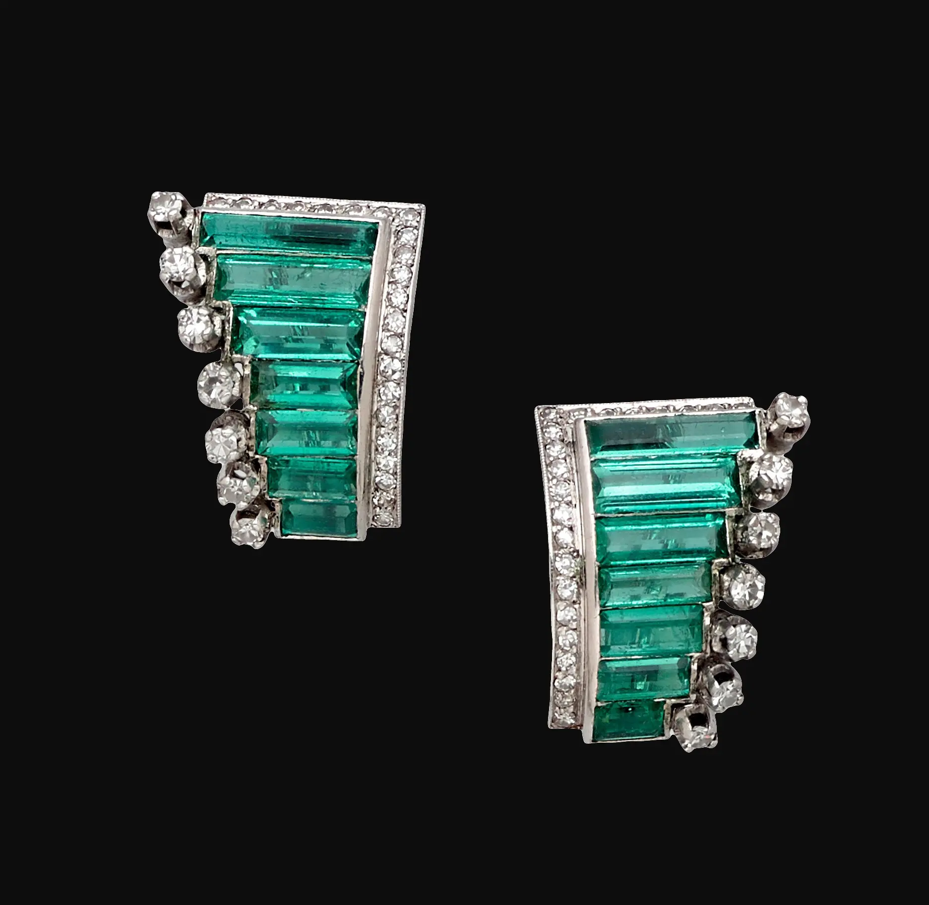 Pair of Art Deco palladium ear clips set with octagonal step-cut Colombian emeralds in a fan motif, bordered by colorless diamonds, 7/8-inch length