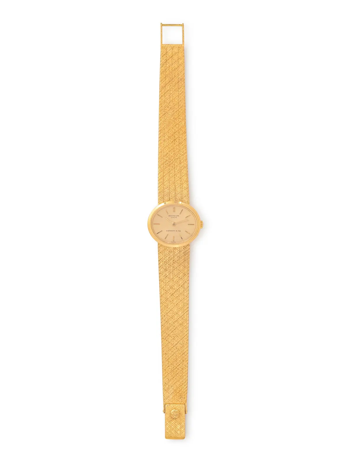 Double-signed Patek Philippe for Tiffany & Co. 18K yellow-gold watch with champagne dial and integrated textured bracelet, manual wind, Swiss hallmarks.